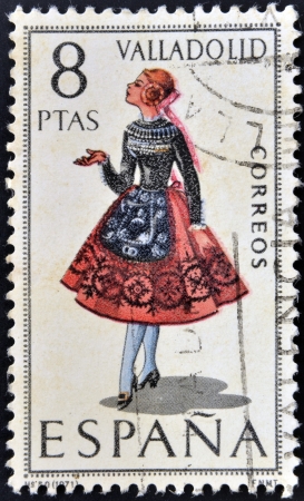 SPAIN - CIRCA 1971: A stamp printed in Spain dedicated to Provincial Costumes shows a woman from Valladolid, circa 1971の写真素材