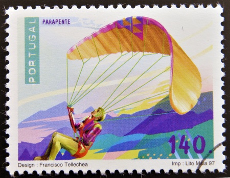 PORTUGAL - CIRCA 1997: A stamp printed in Portugal dedicated to extreme sports, shows paragliding, circa 1997のeditorial素材