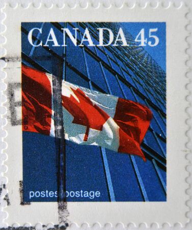 CANADA - CIRCA 1995: A stamp printed in Canada shows image of a the Canadian flag and a modern building, circa 1995 のeditorial素材