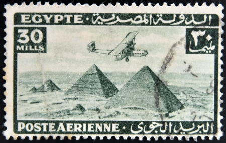 EGYPT - CIRCA 1946: stamp printed in Egypt shows plane over Pyramids at Giza, circa 1946 のeditorial素材