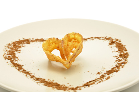 plate with a piece of fried flower decorated with heart-shaped cinnamonの写真素材
