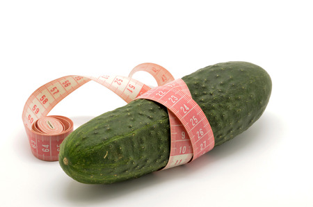 Cucumber and measuring tape isolated on white の写真素材