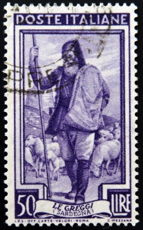 ITALY - CIRCA 1950: a stamp printed in Italy shows Shepherd and Flock, Sardegna, circa 1950 のeditorial素材