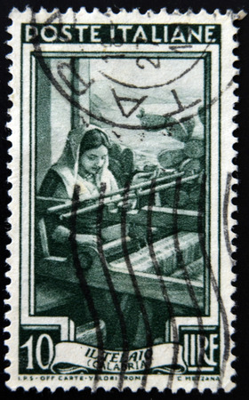 ITALY - CIRCA 1950: A stamp printed in Italy from the "Provincial Occupations" issue shows a Weaver (Calabria), circa 1950. のeditorial素材