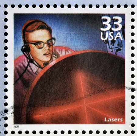UNITED STATES OF AMERICA - CIRCA 1999: Stamp printed in USA dedicated to celebrate the century 1960s, shows lasers, circa 1999のeditorial素材