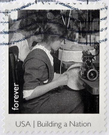 UNITED STATES OF AMERICA - CIRCA 2013: A stamp printed in USA dedicated to building a Nation, shows a millinery apprentice, circa 2013のeditorial素材