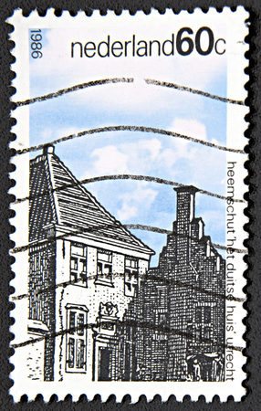 GRANADA, SPAIN - NOVEMBER 30, 2015: A stamp printed in Netherlands shows buildings in city against of blue sky, 1986のeditorial素材