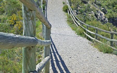 Wooden railing on the stone pathの写真素材