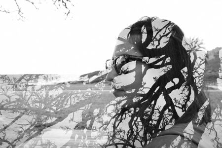 Double exposure of young woman and tree branches, taken with the cameraの写真素材