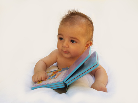 4 months old baby playing with bookの写真素材