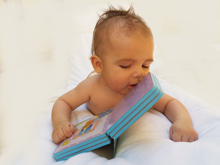 4 monyhs old baby playing with bookの写真素材