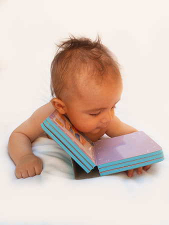 4 months old baby playing with bookの写真素材