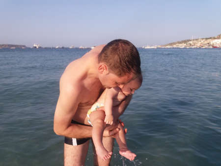 four month old baby boy first time swimming in the seaの写真素材