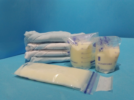 breast milk in storage bags with breast pump blue backgroundの写真素材
