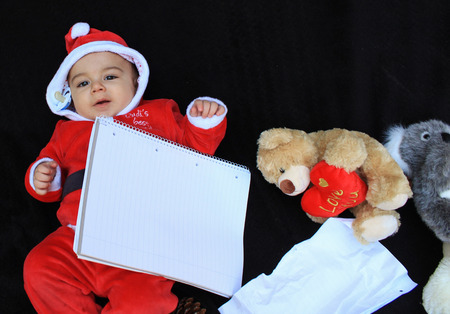 baby boy in santa claus suit playing ,black background copy spaceの写真素材