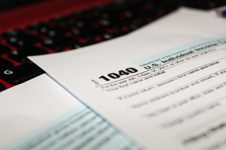 Calendar and form 1040 income tax form for 2017 showing tax day for filing is April 17 2018