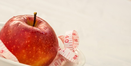 Red apple with measuring tape, weight loss conceptの写真素材