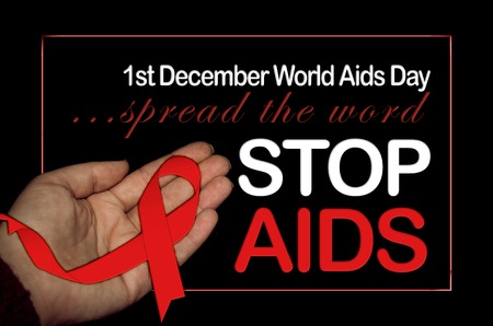 woman hand holding red ribbon for world aids day black backgroundの写真素材