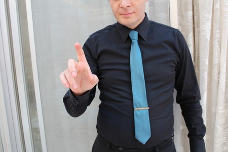 a businessman in a suit and tie pointing with finger, for implementation of graphic futuristic. Concept: business, graphic, holography, alpha channel.の写真素材