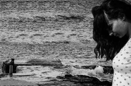 young woman suffering from depression locking down to the sea black and whiteの写真素材
