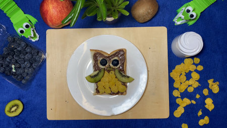 Creative kids breakfast, Owl shaped chocolate spread on the bread surrounded by fruits. High quality photoの写真素材