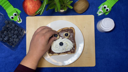Chocolate spread on the bread decorated as a teddy bear. Creative kids breakfast. High quality photo