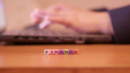 Hand typing on the laptop keyboard with letters in front spelling finance. High quality photoの写真素材