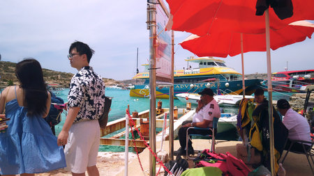 Comino, Malta 29.05.2024 - Blue lagoon. Tourists on the port waiting for ferry to Malta and Gozo. High quality photoのeditorial素材
