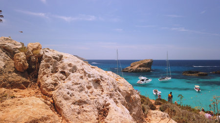 Comino, Malta 29.05.2024 - Blue lagoon, revealing shot from behind the stone. High quality photo