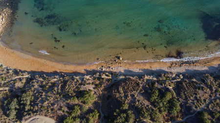 Morning golden light on a golden sand beach and green sea. Aerial, Malta, Ghajn Tuffieha bay. High quality photoの写真素材