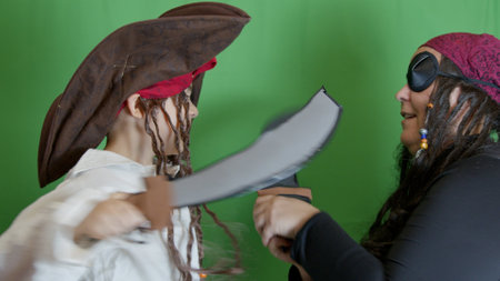 Pirate game. Mom and son having fight with fake cutlasses. Halloween activity. High quality photoの写真素材