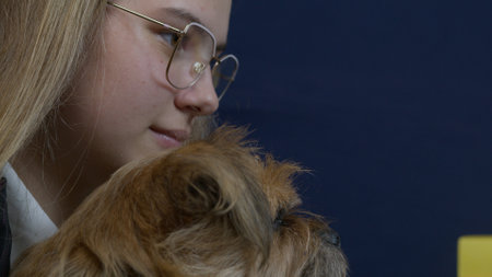 Young blonde caucasian business woman working from home and holding her pet dog. High quality photoの写真素材