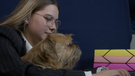 Young caucasian woman holding a dog pet and working from home on laptop. Remote classes or job. High quality photoの写真素材