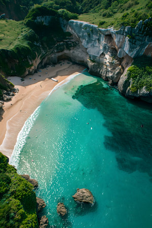 Stunning aerial view showcasing a hidden beach surrounded by dramatic cliffs and lush greenery.の素材