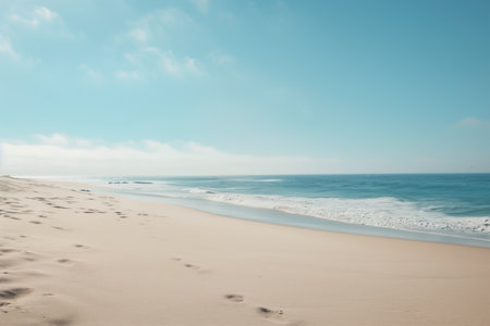 A tranquil ocean coastline featuring soft sand, clear blue skies, and gentle waves under the warmth of the sun. Captures the serenity and beauty of nature by the sea.の素材