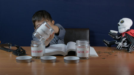 Child engaged in an experiment involving labeled jars, with a skeleton model for creative expression, illustrating a unique and imaginative educational moment.の写真素材