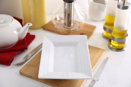 Empty white plate on kitchen table, closeup. Space for textの写真素材