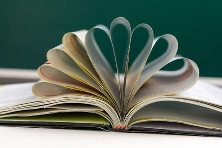 Pages of book curved into a heart shape. teachers day conceptの写真素材