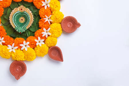 Flower Rangoli for Diwali Festival made using Marigold and leaf and Oil Lamp over white background,の写真素材