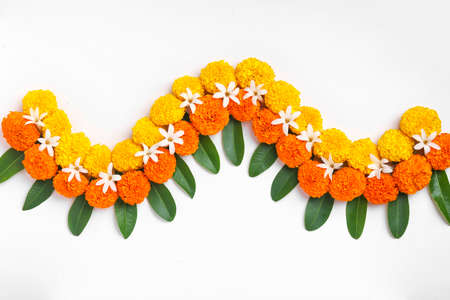Flower Rangoli for Diwali Festival made using Marigold and leaf and Oil Lamp over white background,