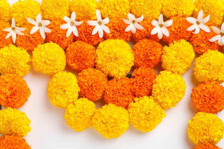 Flower Rangoli for Diwali Festival made using Marigold and leaf and Oil Lamp over white background,の写真素材