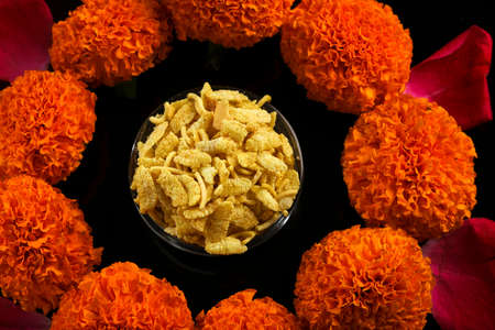 Diwali Rangoli or design made using Indian snacks , lamp and flowersの写真素材