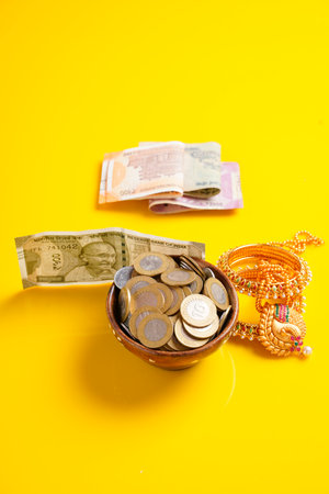 Indian rupees note,coins and gold jewelry over yellow backgroundの写真素材