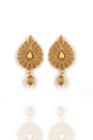 Beautiful Golden pair of earrings on white background. Luxury female jewelry, Indian traditional jewellery, kundan earrings,Bridal Gold earrings wedding jewelleryの写真素材