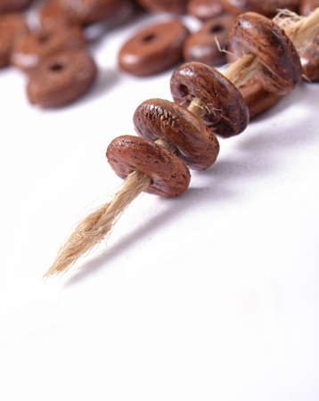 Wooden beads with natural jute string Twine Rope on white background. Close up, macro.の写真素材