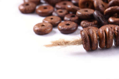 Wooden beads with natural jute string Twine Rope on white background. Close up, macro.の写真素材