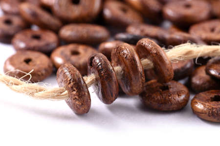 Wooden beads with natural jute string Twine Rope on white background. Close up, macro.の写真素材