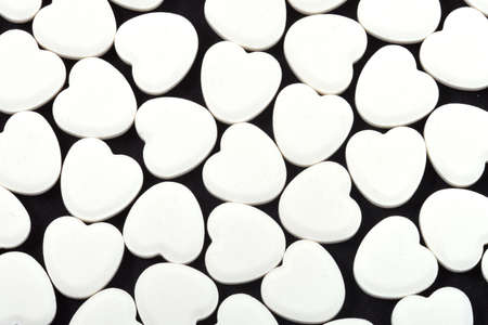 Heart shaped pills on a black background. Medicines that help people.の写真素材