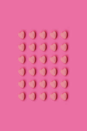 Heart shape Pharmaceutical medicine tablet on a pink background,Medicine creative concepts. Minimal style with colorful paper backdrop.Trendy colors,Trendy patternの写真素材