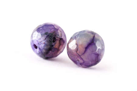 Patterned purple agate beads isolated on white,Round Agate beads,Semi Precious stones. Natural mineral beads. Beads made of natural stones to create jewelry.の写真素材